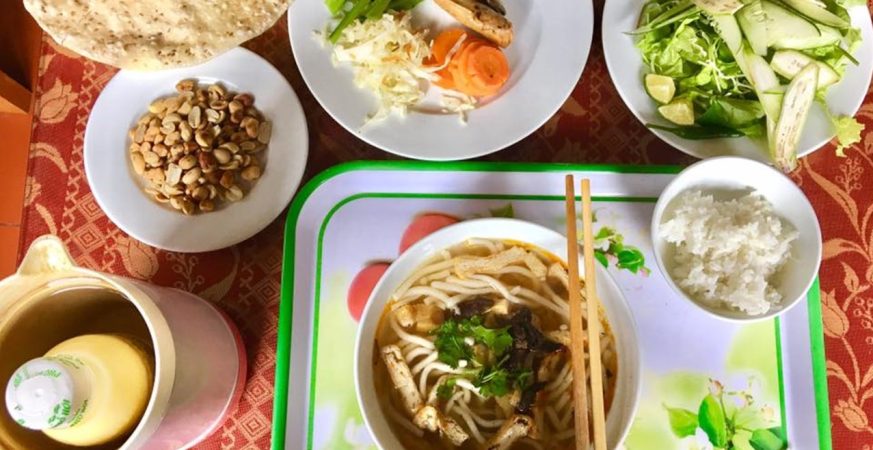 Colorful Vietnam’s Veggie Food including pho chay, bánh mì chay, and fresh spring rolls served on traditional plates with herbs and chopsticks.